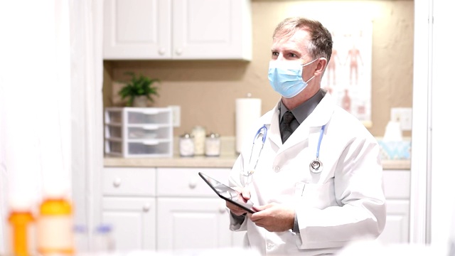 医生使用平板电脑，戴口罩。视频下载