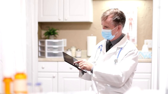 医生使用平板电脑，戴口罩。视频下载