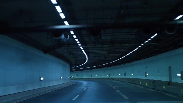 一輛車在夜間行駛在高速公路的隧道里視頻下載