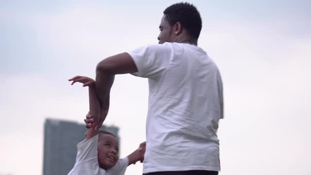 快乐的非裔美国父子在公园里玩耍，幸福的家庭观念，父母和孩子在公园里玩耍视频素材