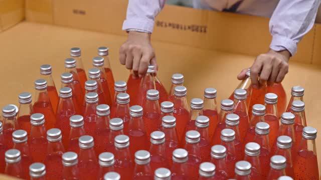 工人将瓶装果汁从纸板箱中取出，送到饮料加工厂视频下载