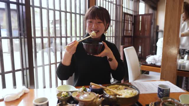 年轻女子在日本餐馆吃“Donabe Gohan”健康的日本食物视频素材
