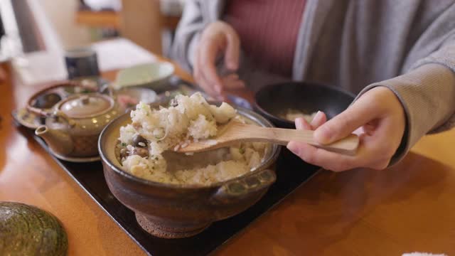 在日本餐馆里，一名年轻女子给一碗米饭上菜视频素材