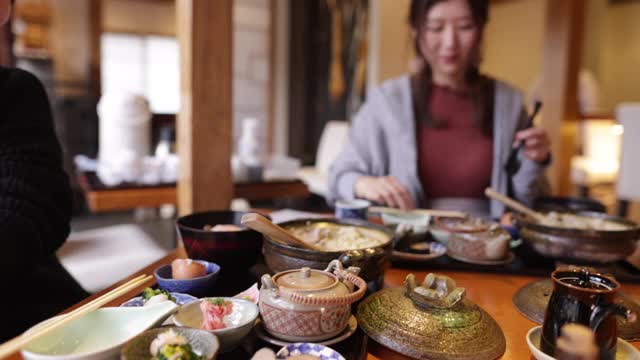 年轻女性在日本餐馆吃“Donabe Gohan”健康的日本食物视频素材