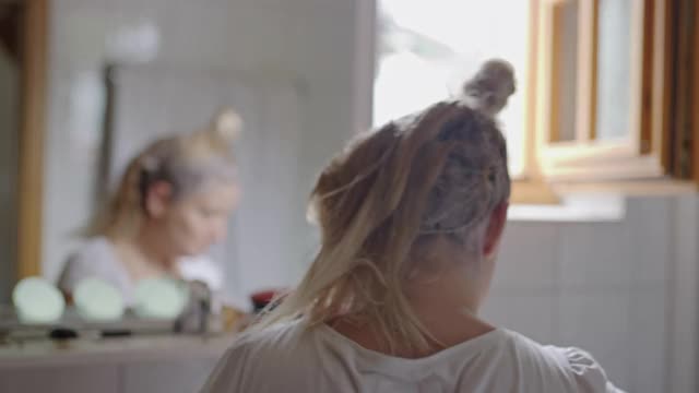 一个女人在镜子前染头发视频素材