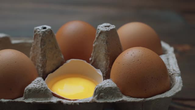 新鲜的鸡蛋放在桌子上的硬纸盒里。幻灯片拍摄视频素材