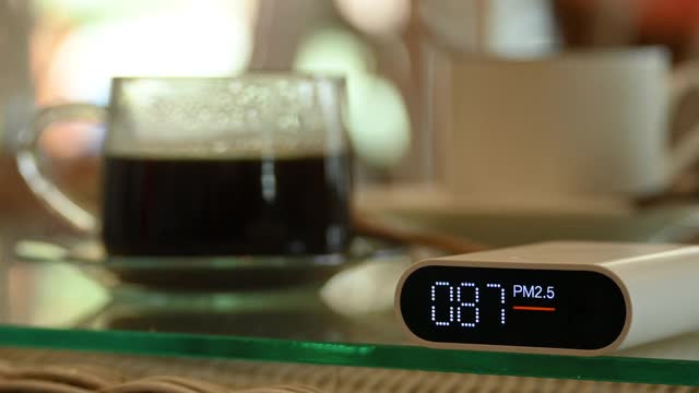 空气粉尘污染的自动测量监测仪pm2.5与不健康的咖啡与坏的一天视频素材