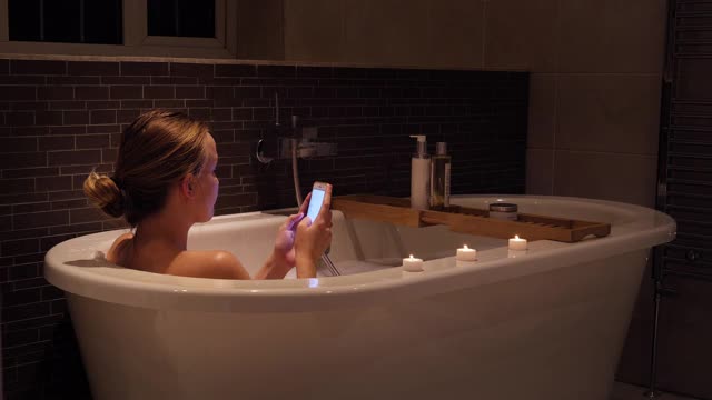 年轻女子在洗澡时打电话视频素材