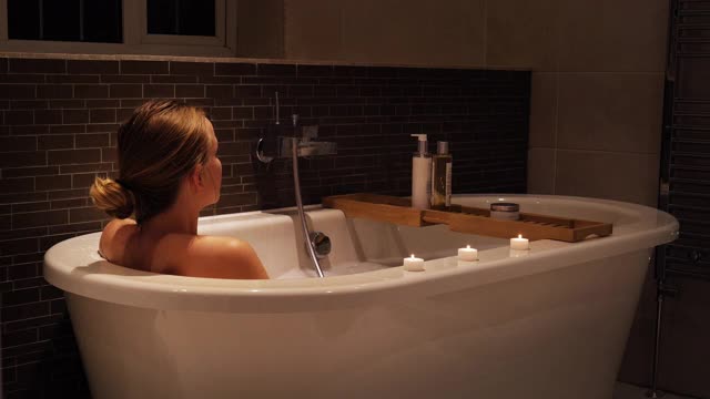 年轻女子在浴缸里下沉，放松视频下载