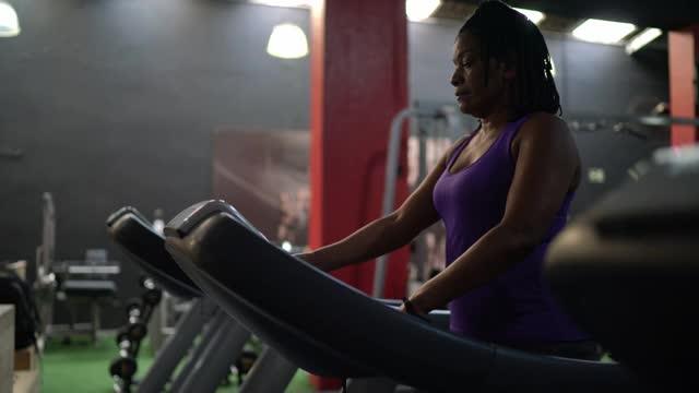 在健身房跑步机上的成熟女人视频素材