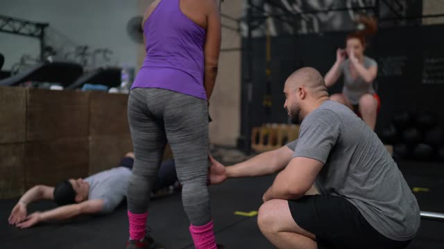 健身教练在健身房帮助成熟女性锻炼视频素材