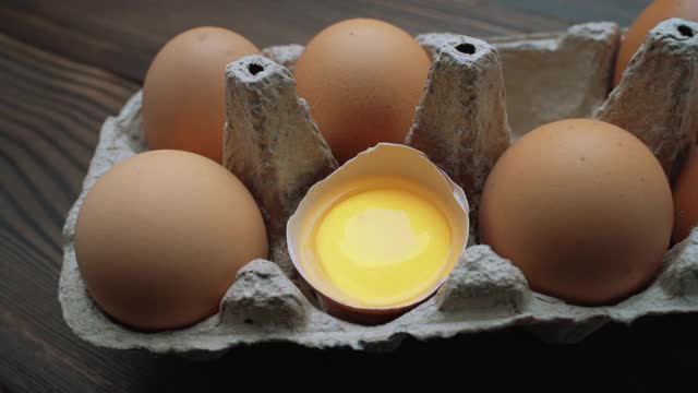 新鲜的鸡蛋放在桌子上的硬纸盒里。幻灯片拍摄视频素材