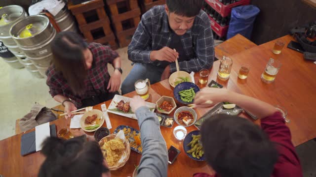 桌面视图-一群亚洲人在居酒屋喝酒吃饭视频素材