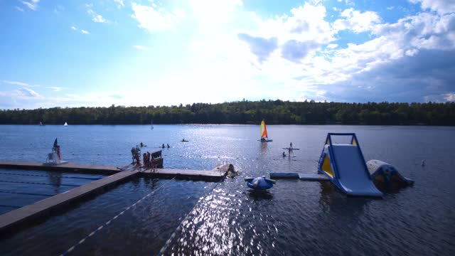 无人机拍摄的孩子们在湖边参加各种水上活动的夏令营视频下载