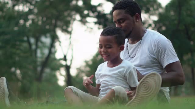 快乐的非裔美国父亲和儿子在公园玩耍，幸福的家庭观念视频素材