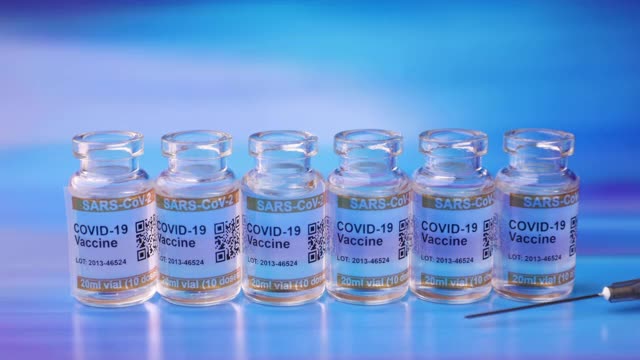 一系列透明的COVID-19疫苗瓶，标签为SARS-CoV-2抗冠状病毒注射注射器视频素材