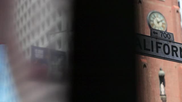 慢动作平移镜头的加利福尼亚街道标志对钟塔在城市-旧金山，加利福尼亚视频下载