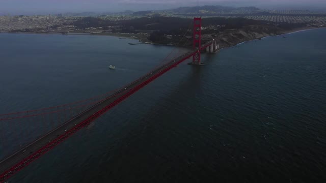 在日落时分，无人机在旧金山上空的著名大桥上的车辆上拍摄金门大桥视频素材