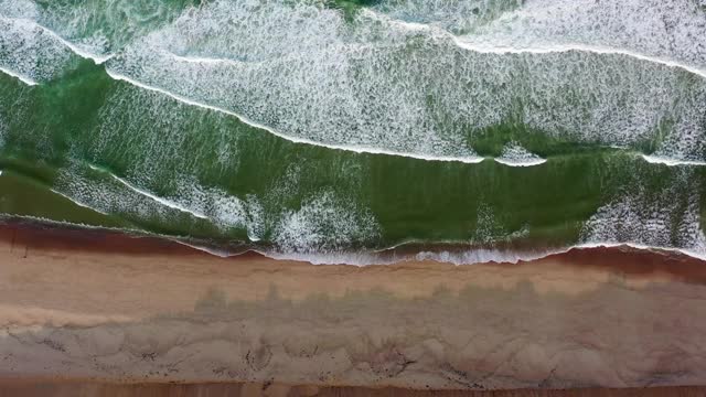 航拍拍海浪溅在海滩上，无人机飞过海岸线-科德角，马萨诸塞州视频下载