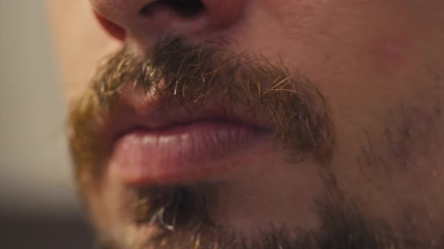 一个男人用电动剃须刀刮掉他的胡子，视频素材