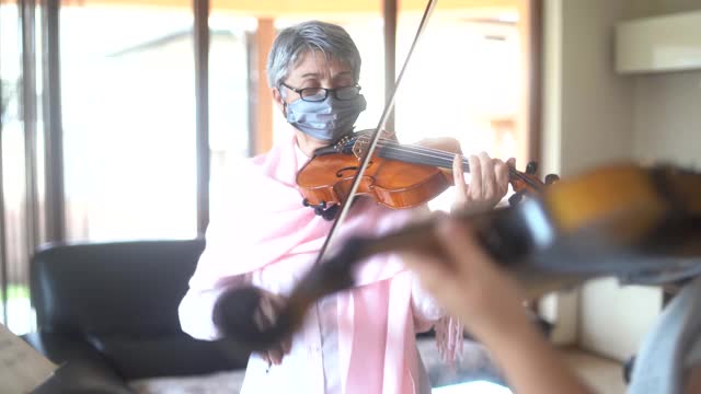 老师和一个年轻的女孩一起拉小提琴在流行时期视频素材