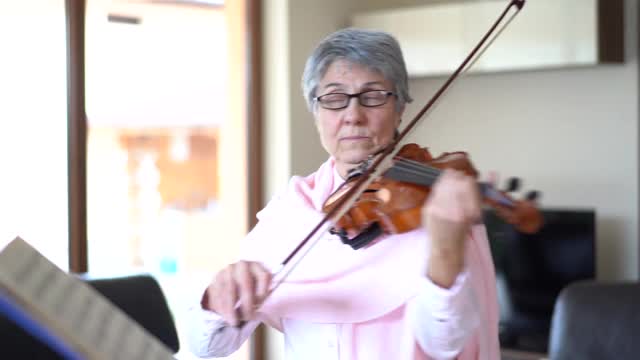 老女人在家里拉小提琴视频素材