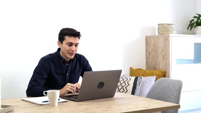 年轻的商人在家庭办公室用笔记本电脑在视频电话会议上交谈-社会距离和虚拟培训的概念视频素材