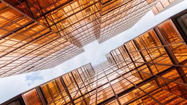 时间流逝香港摩天大楼的上升角度与高楼之间的云反射视频素材