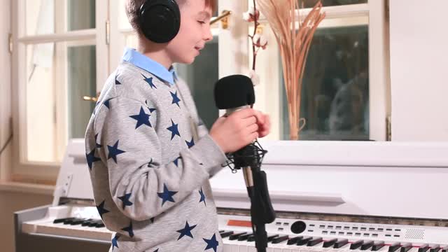 少年准备录制歌曲。音乐教育儿童在麦克风中发声视频下载