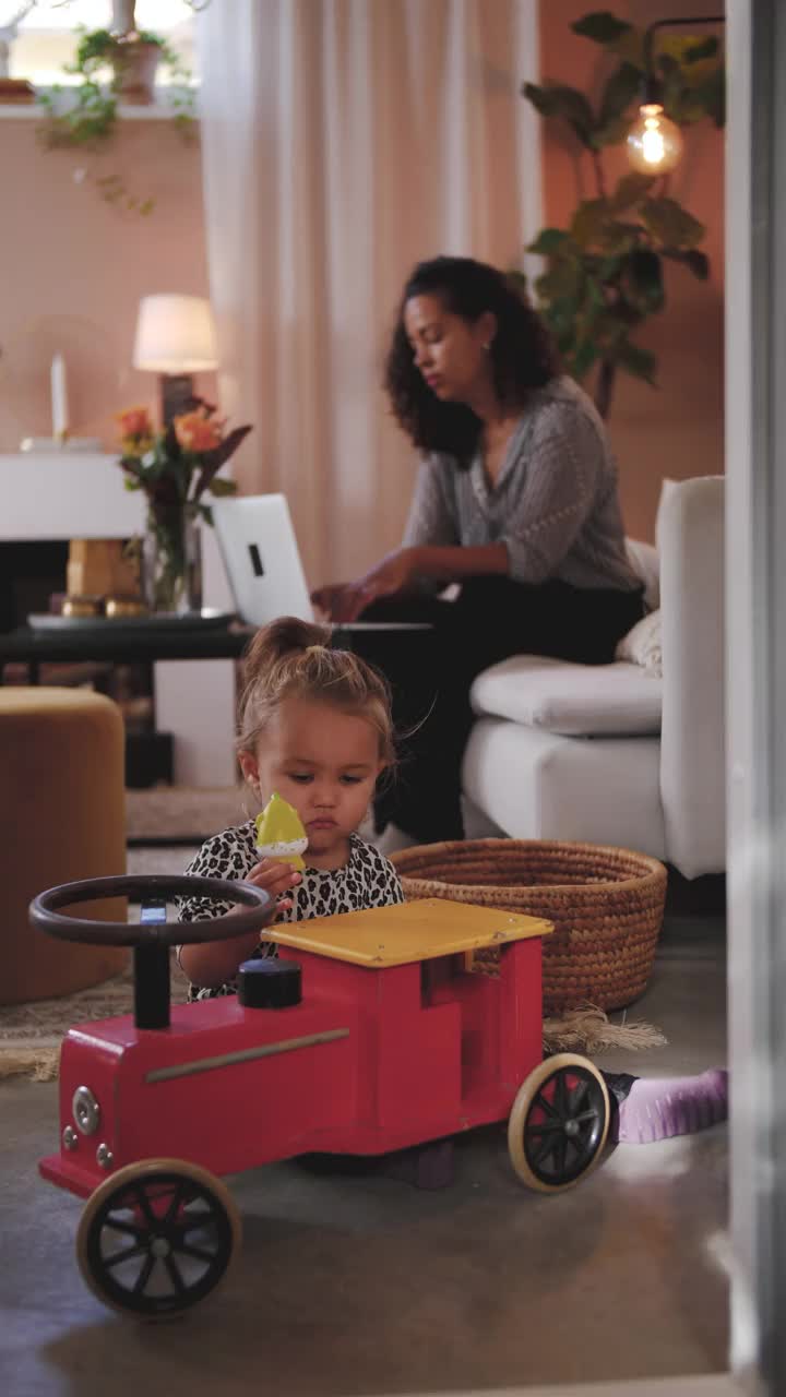 这是一位女商人用笔记本电脑拍摄的照片，而她的女儿则在家里的客厅里玩玩具视频素材