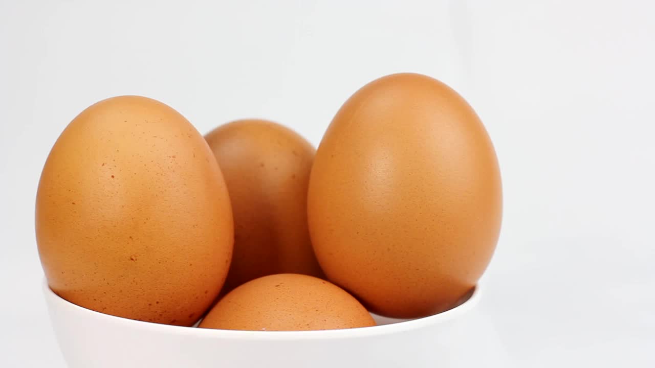 鸡蛋在白色背景上旋转。一个鸡蛋的特写视频素材