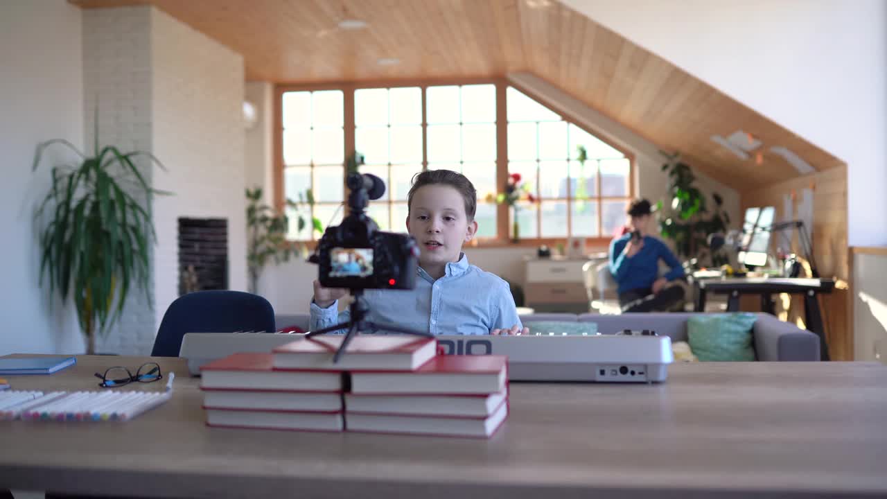 男孩录制关于在家玩合成器的视频教程视频素材
