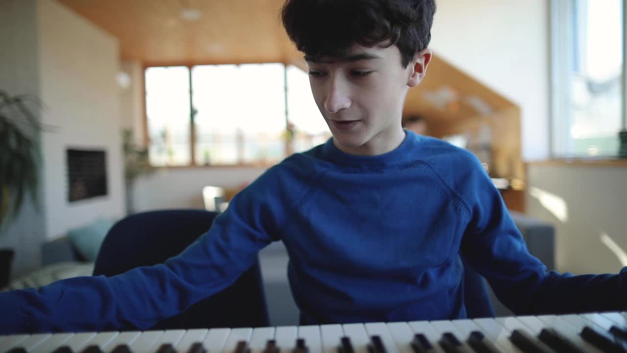 十几岁的男孩录制视频教程关于在家里玩合成器视频下载