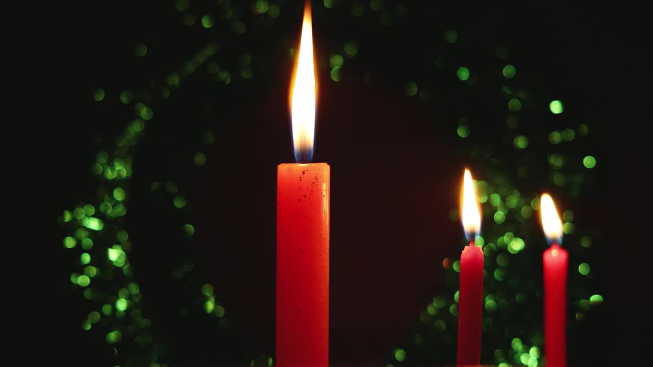 三支独立的蜡烛在黑暗抽象的散景背景下点亮。很适合作为圣诞背景。视频素材