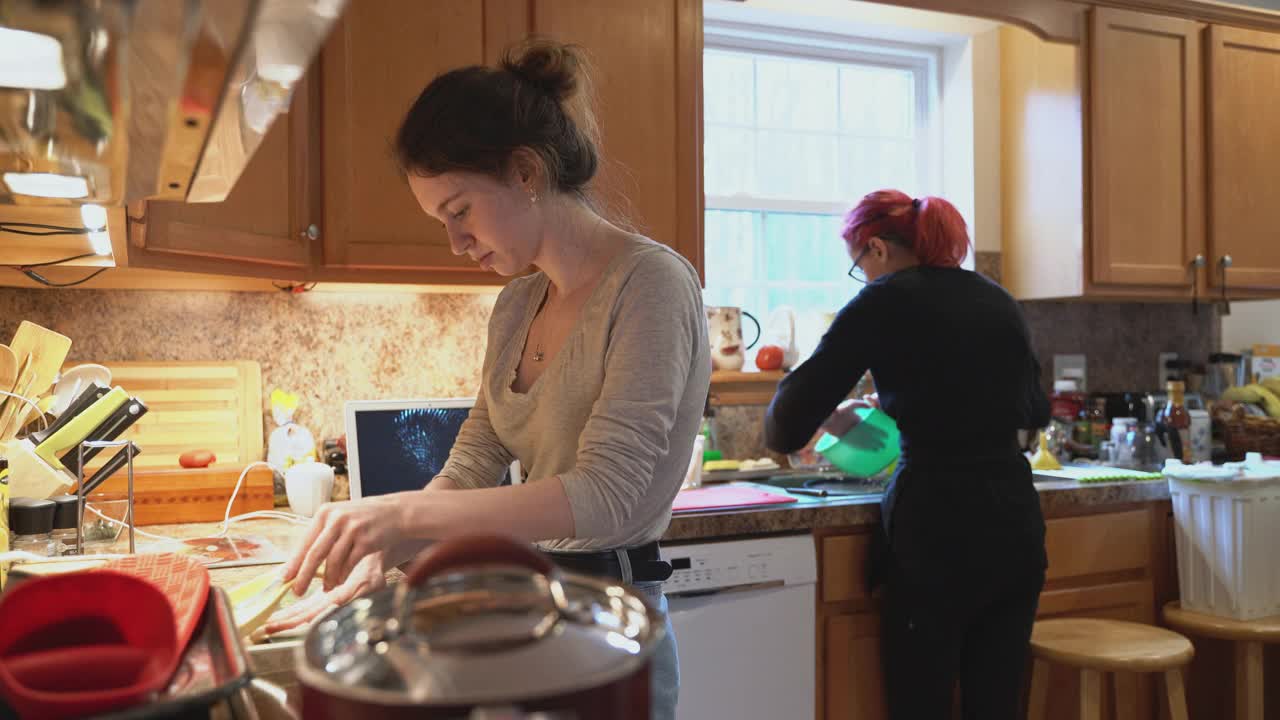 祖母和她的两个孙女正在厨房里一起为家庭晚餐做饭视频下载