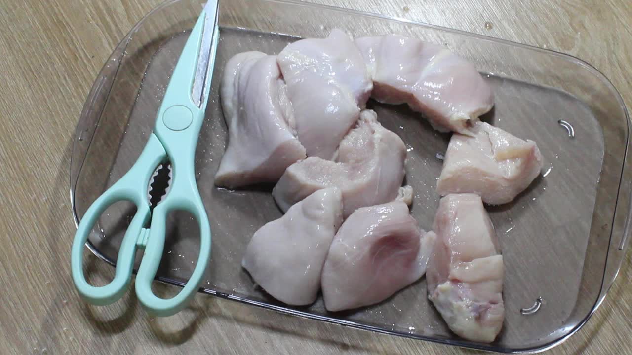 用锋利的切肉剪刀将鸡胸肉切成小块。视频下载