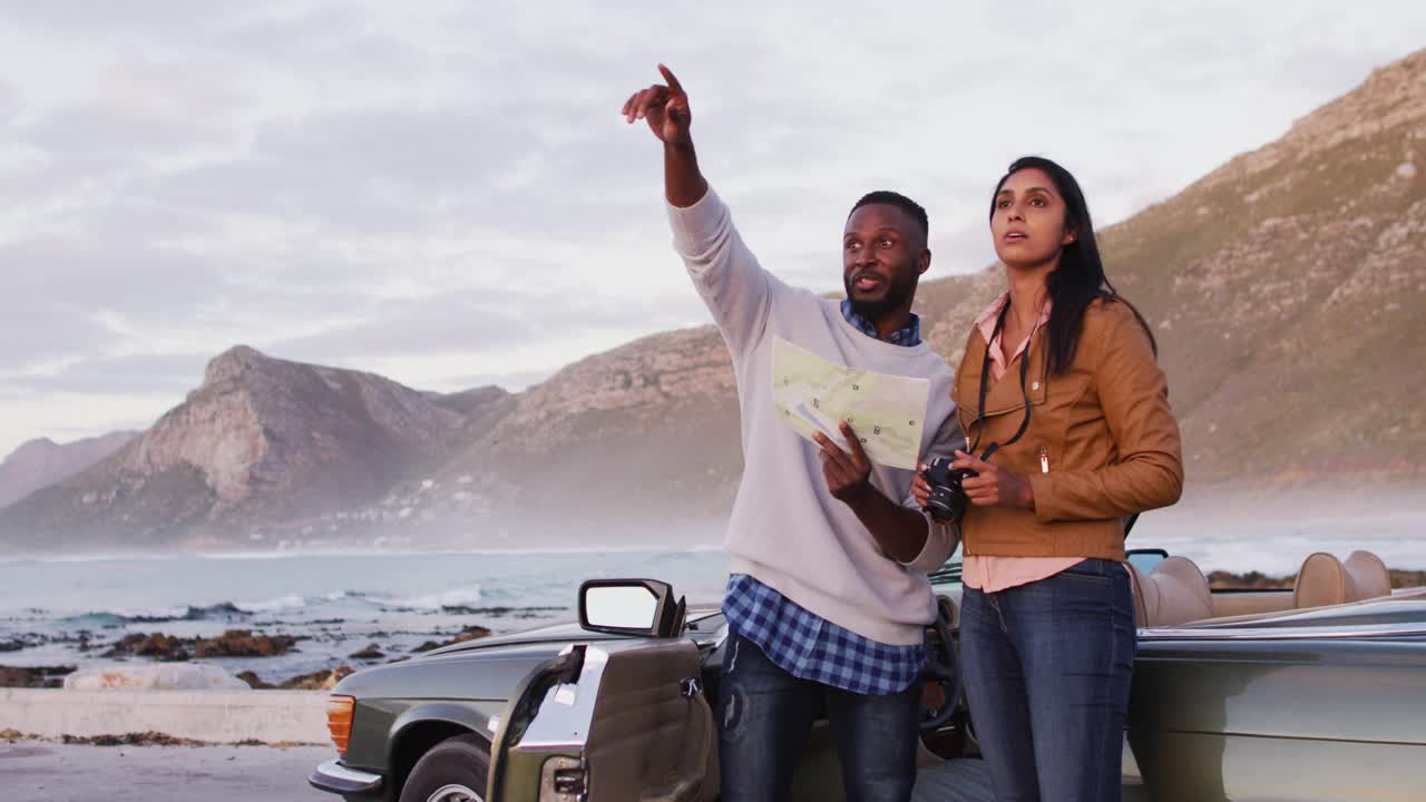 一对非洲裔美国夫妇站在敞篷车附近用地图问路视频下载
