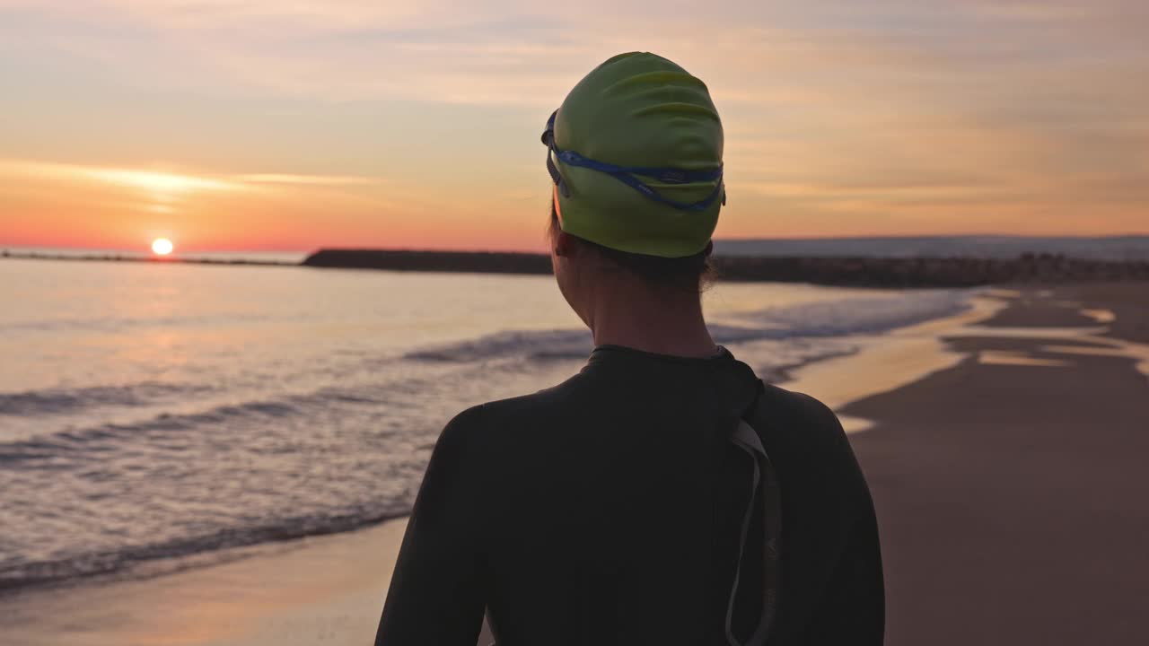 黎明时分的海滩上成熟的女性游泳者的偷拍肖像视频下载