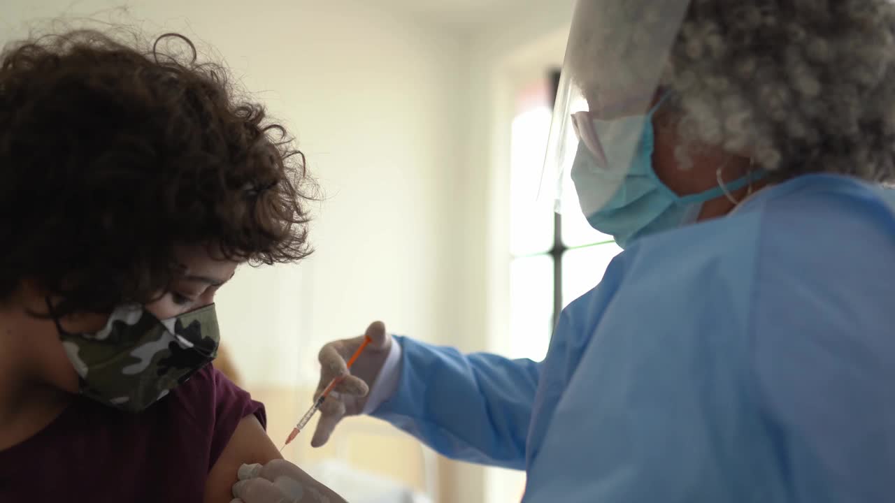 十几岁的男孩在接种疫苗后戴上口罩庆祝视频下载