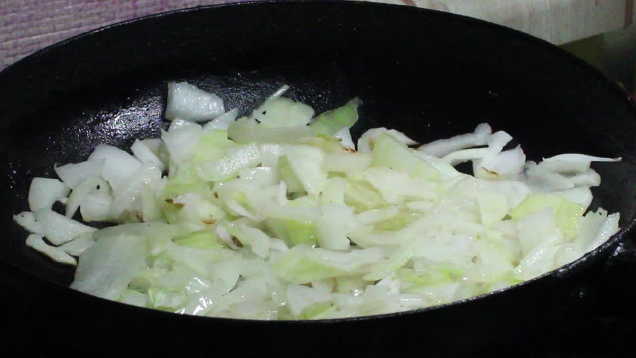 用橄榄油煎炒洋葱。洋葱在黑油锅里煎视频下载