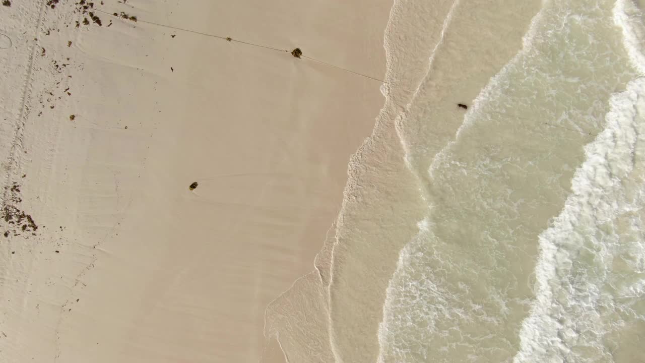 人们在海滩享受阳光的一天，无人机上升在岸上的船与绿松石水-图卢姆，墨西哥视频下载