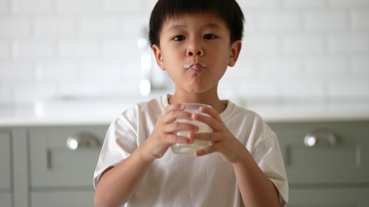 亚洲小孩早餐喝一杯牛奶。健康早餐的概念视频下载