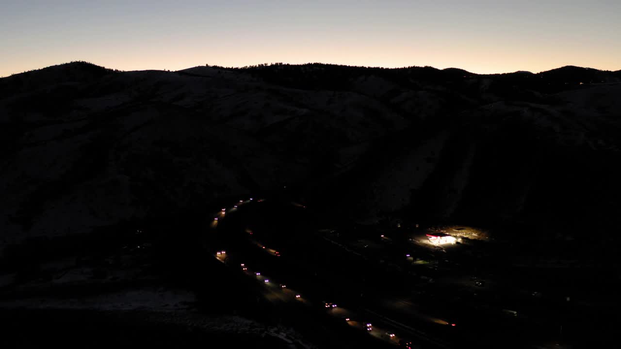 在黄昏在山麓的高速公路上行驶的车辆的航拍，无人机在冬天的景观-丹佛，科罗拉多州视频下载