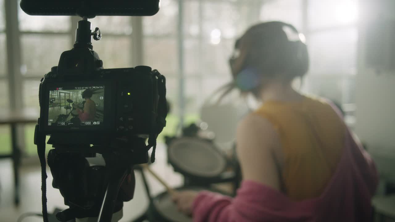 年轻女子在客厅里练习电子鼓。录制音乐会话视频素材