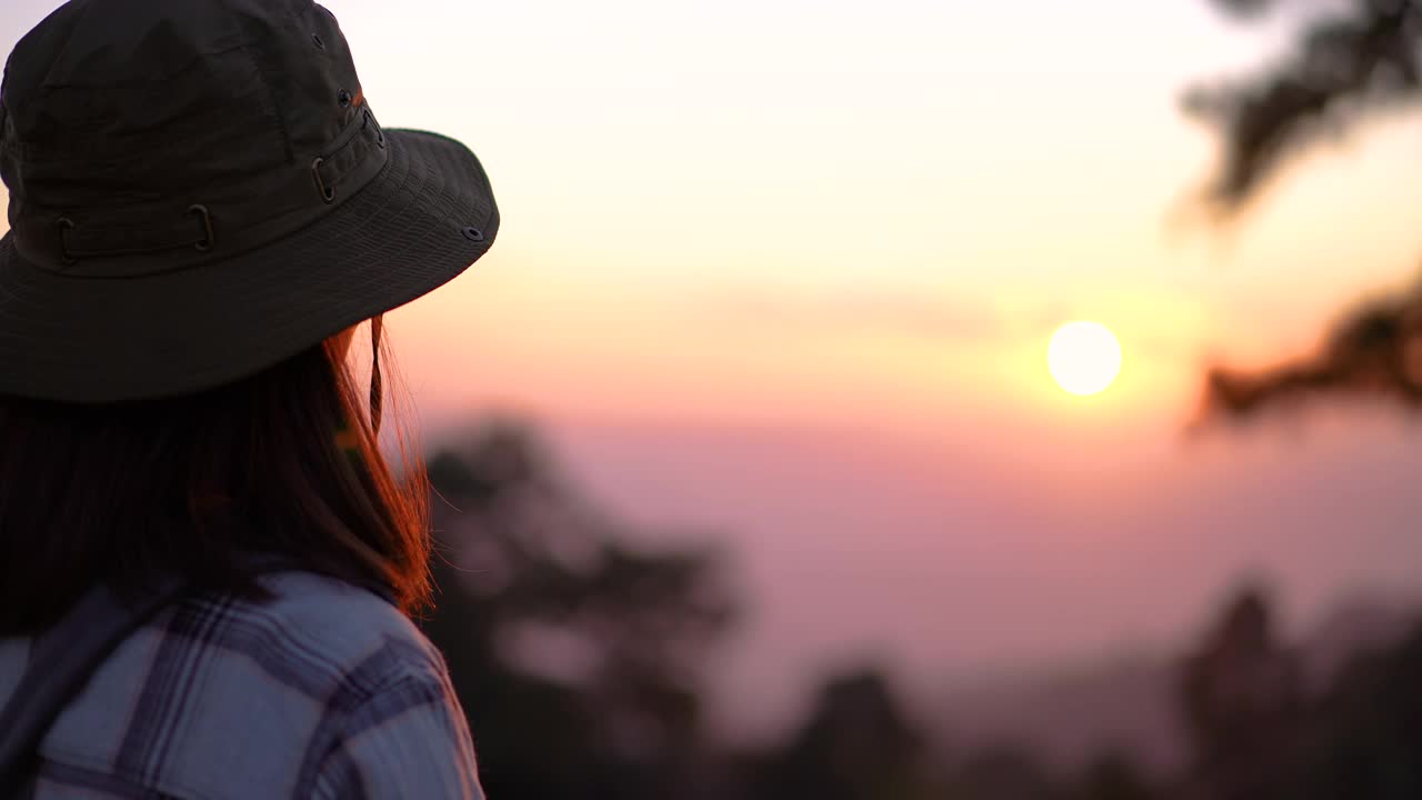 女旅行者在山上一個美麗的地方拍攝日落視頻素材
