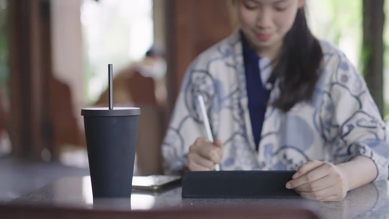 年轻的亚洲女性用环保可重复使用的咖啡杯喝水视频下载