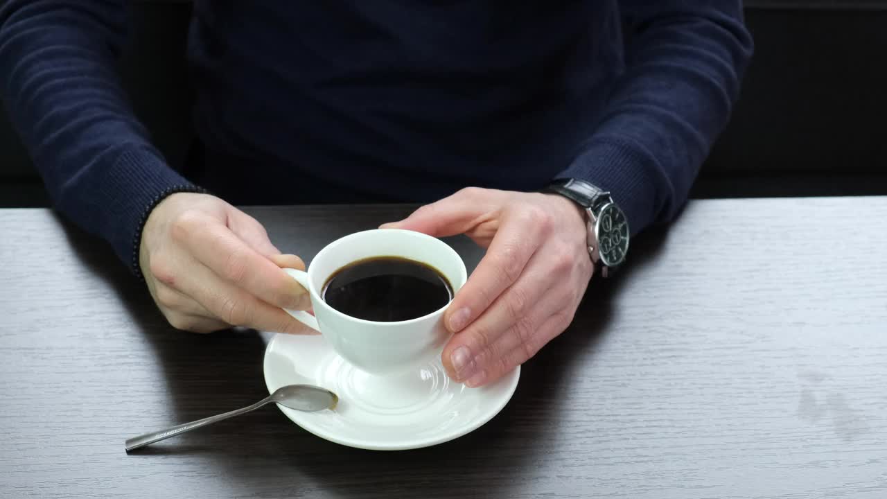 坐在桌子边喝咖啡的人。有选择性的重点。视频素材