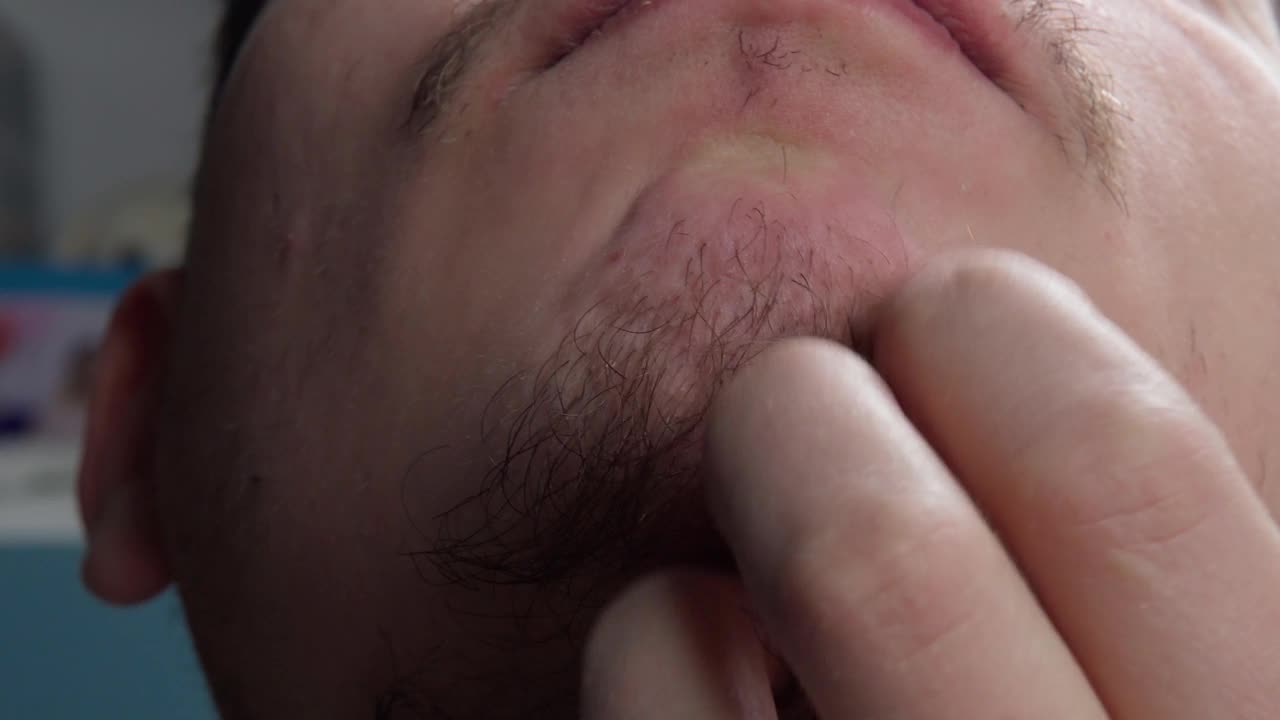 年轻的大胡子男子的特写，触摸他的胡子。有选择性的重点视频素材