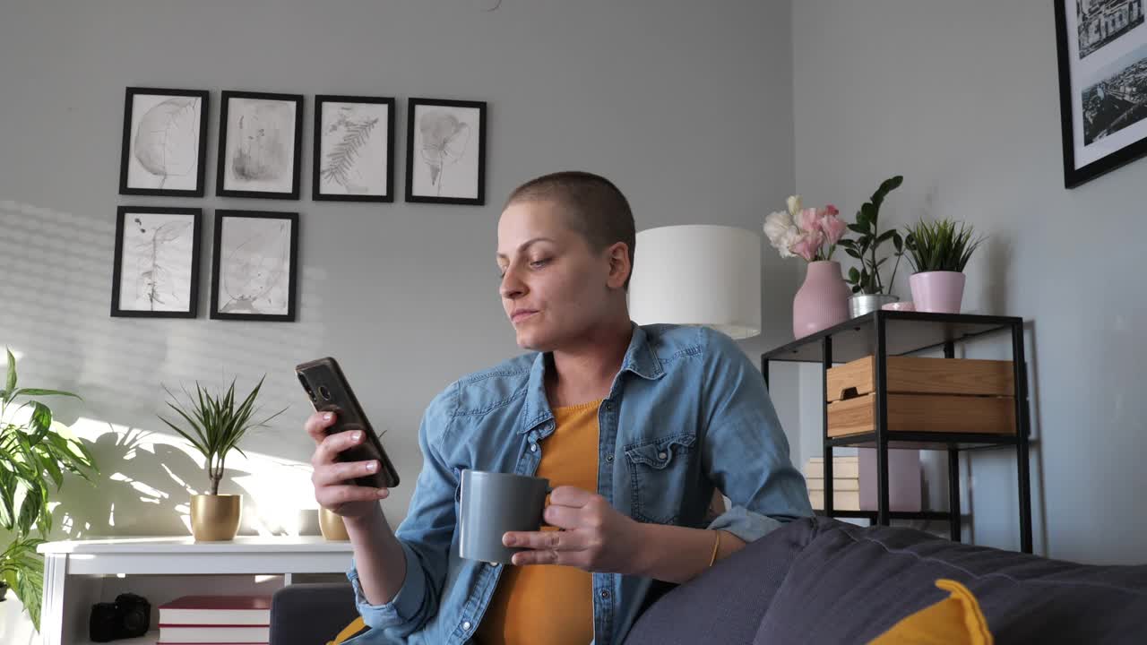 微笑的千禧妇女患有淋巴结癌在家喝咖啡视频下载