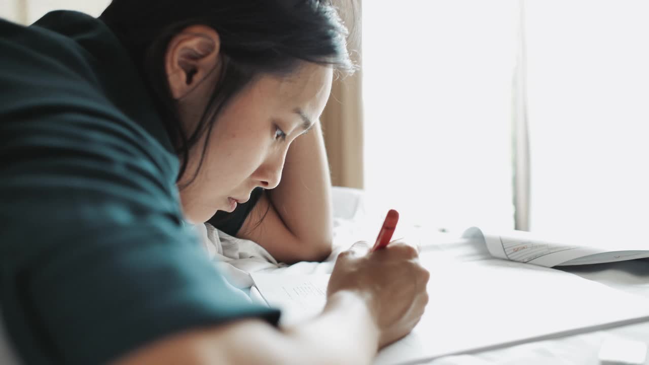 特写女人在纸上阅读，翻页和使用铅笔在文件上标记文本视频素材